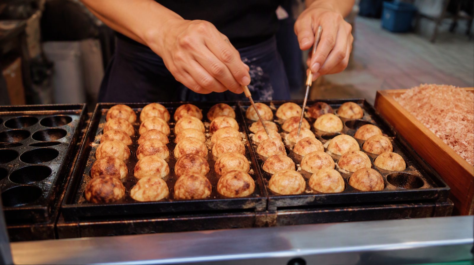 Bolas de pulpo «takoyaki» que se van volteando en un puesto callejero de Osaka