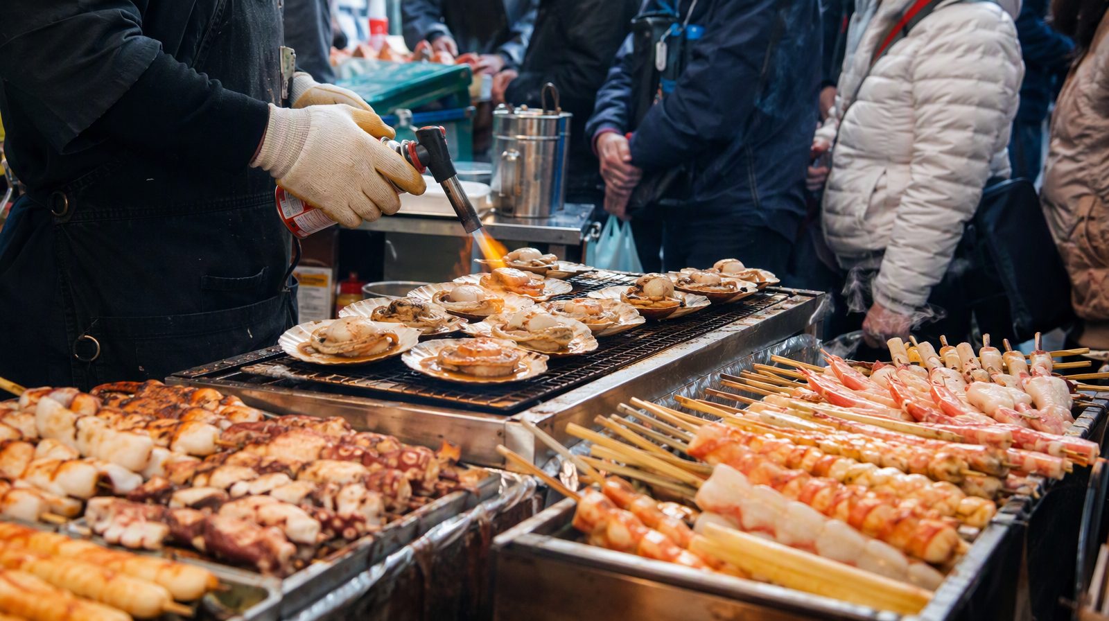 Brochettes de fruits de mer en train de griller au marché de Kuromon, à Osaka